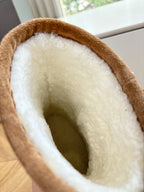 Tan boot interior with plush shearling lining and stitched opening rim