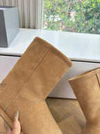 Tan suede mid-calf boot with stitched seams and shearling-lined cuff