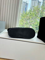Black rubber outsole with tread detail beside black ankle boot