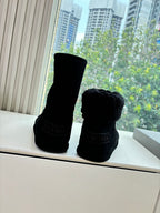 Black ankle boots with fuzzy cuffs, rear view with logo detail