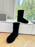 Black suede ankle boots, one front and one side view on display
