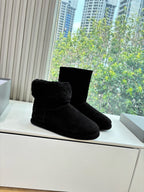 Black suede ankle boots with fuzzy top, single pair on display