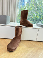 Balenciaga dark brown suede boots, one foot lifted, mid-calf height