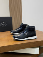 Prada dark leather sneakers, angled side view with lace-up and logo patch.