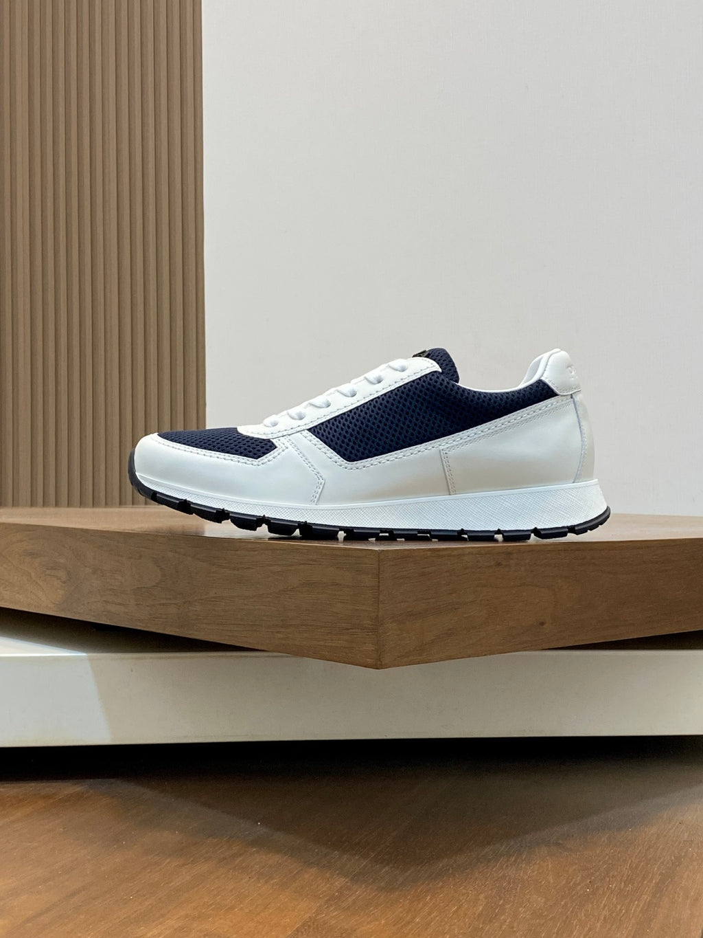 White and navy unisex lace-up sneaker, side view with thick tread sole
