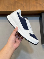 White and navy unisex lace-up sneaker with side panel, stitching, and textured sole