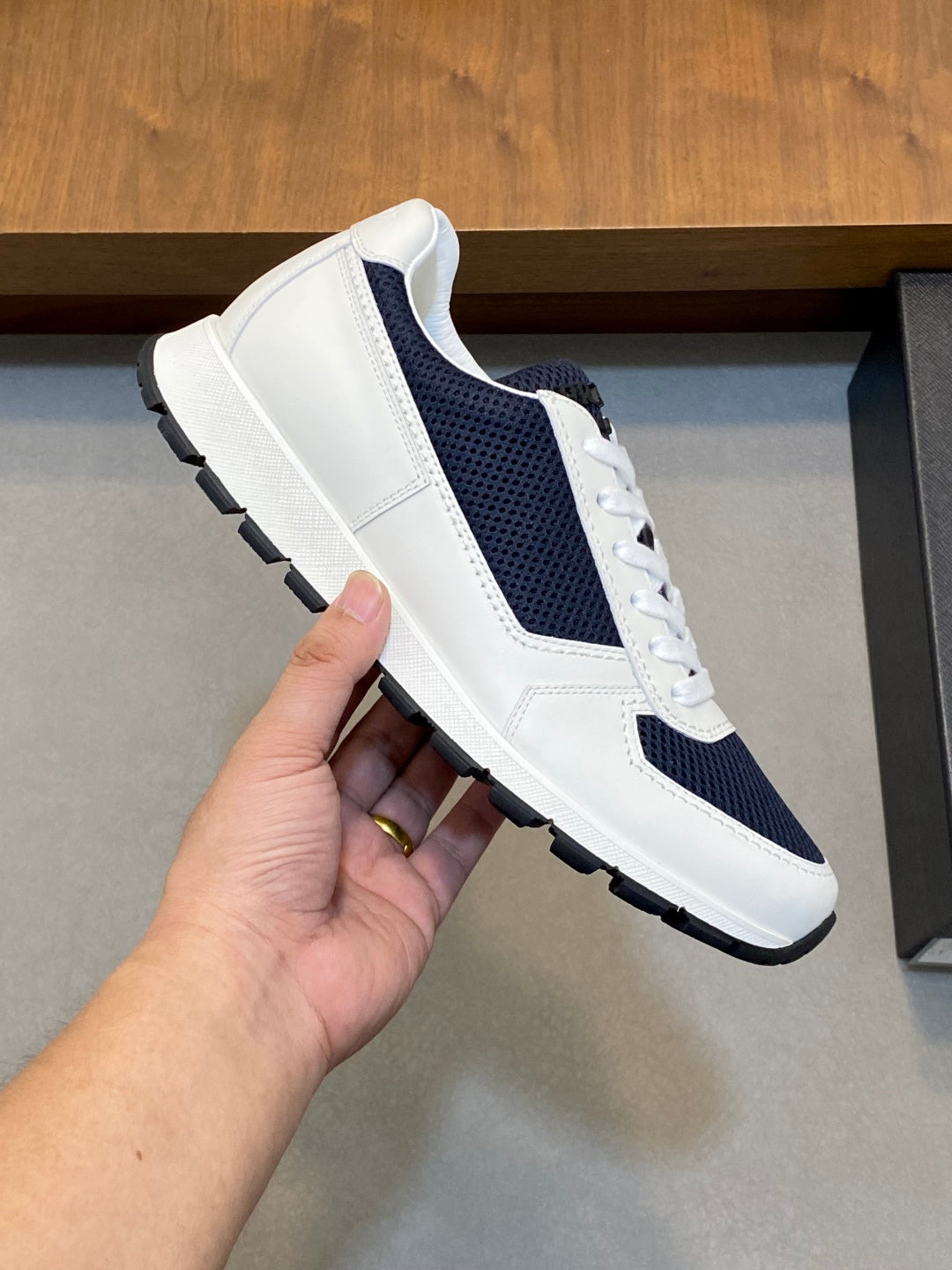 White and navy unisex lace-up sneaker with side panel, stitching, and textured sole
