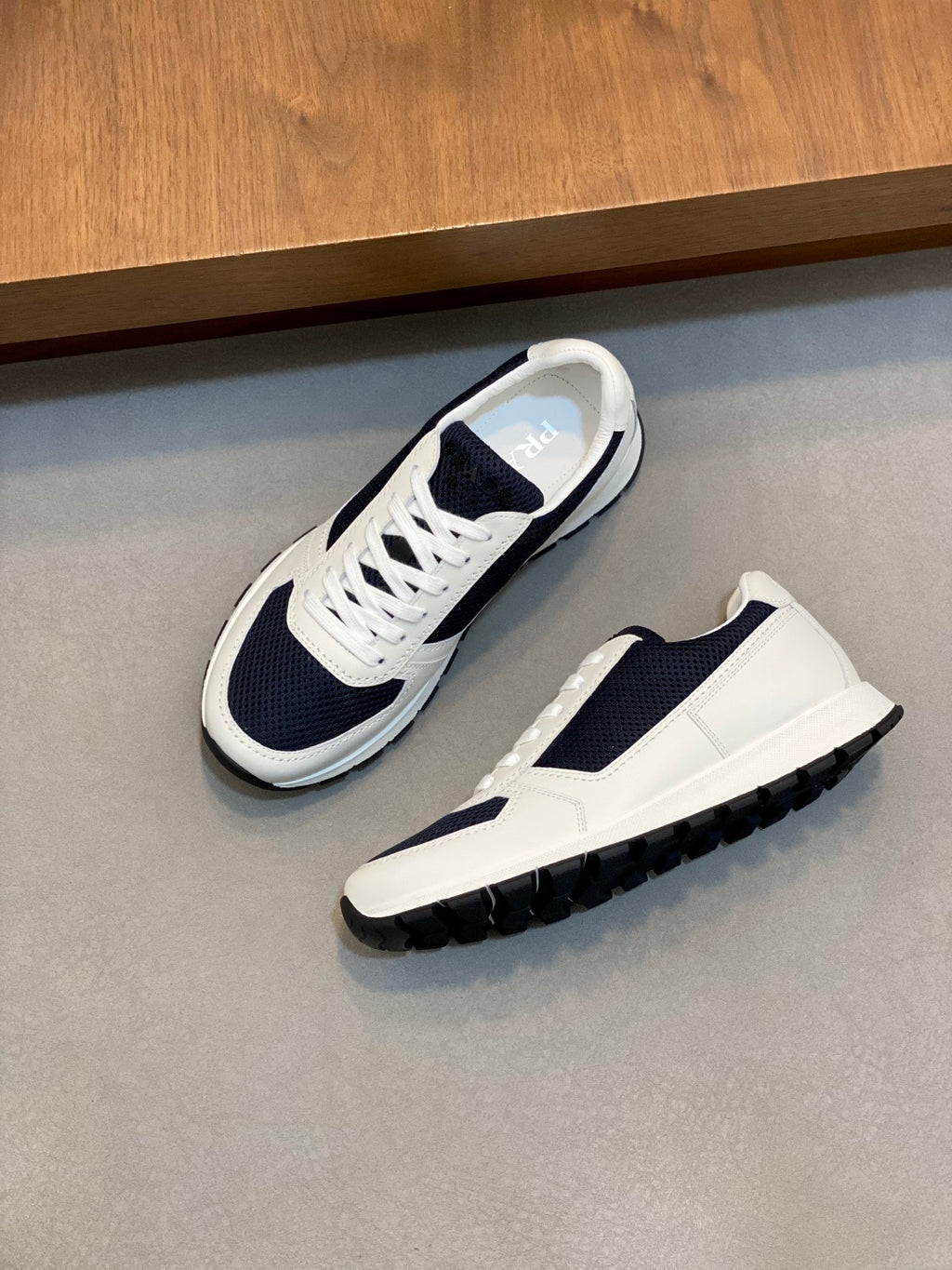 White and navy unisex lace-up sneakers with chunky tread outsole and lace-up closure