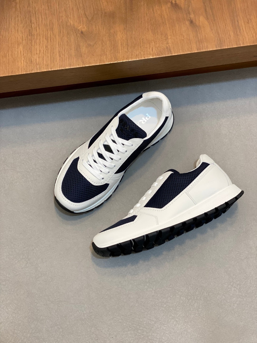 White and navy unisex lace-up sneakers with chunky tread outsole and lace-up closure