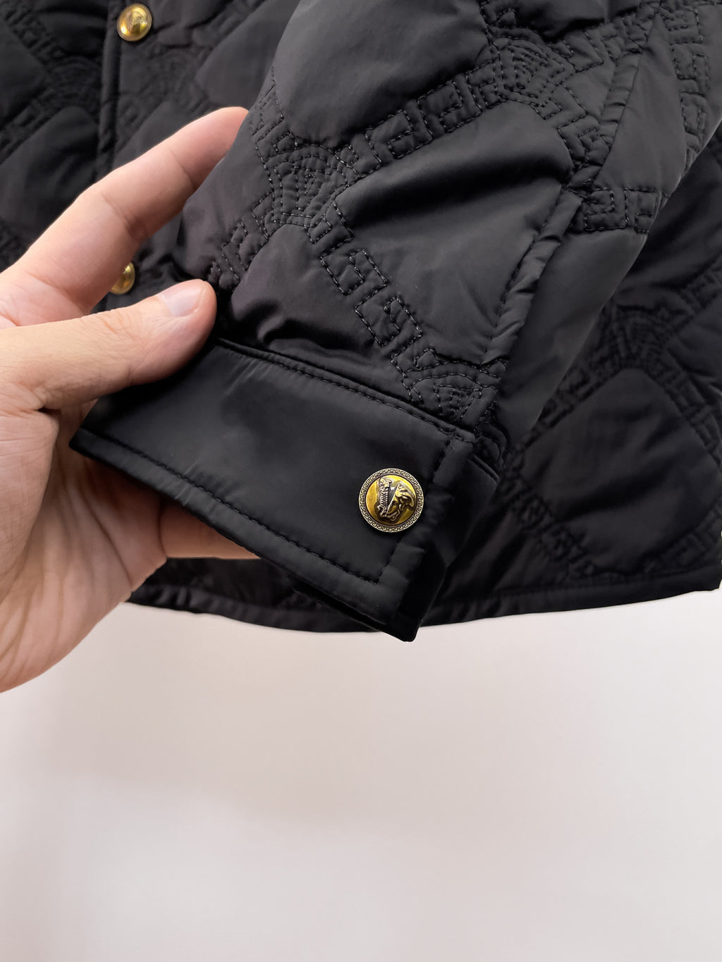 Versace quilted jacket hem detail with gold snap button and diamond quilting