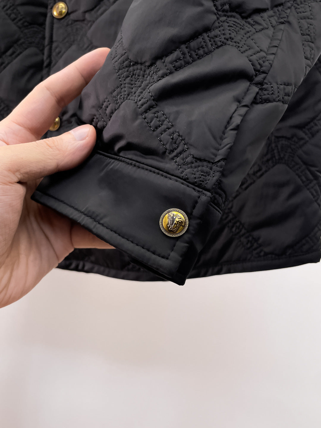 Versace quilted jacket hem detail with gold snap button and diamond quilting