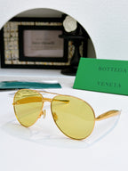 Bottega Veneta sunglasses with gold frame and yellow tinted lenses