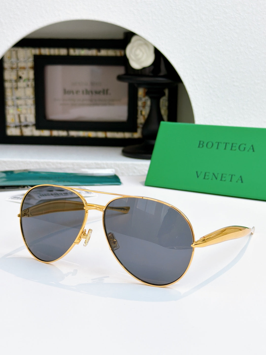 Bottega Veneta sunglasses with gold frame and dark blue tinted lenses