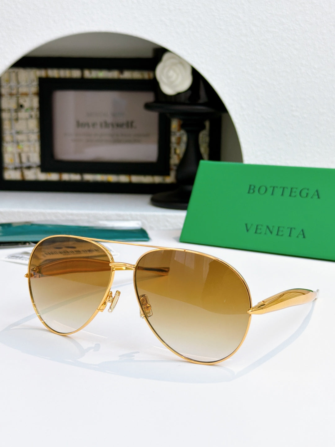 Bottega Veneta aviator sunglasses with gold frame and amber tinted lenses