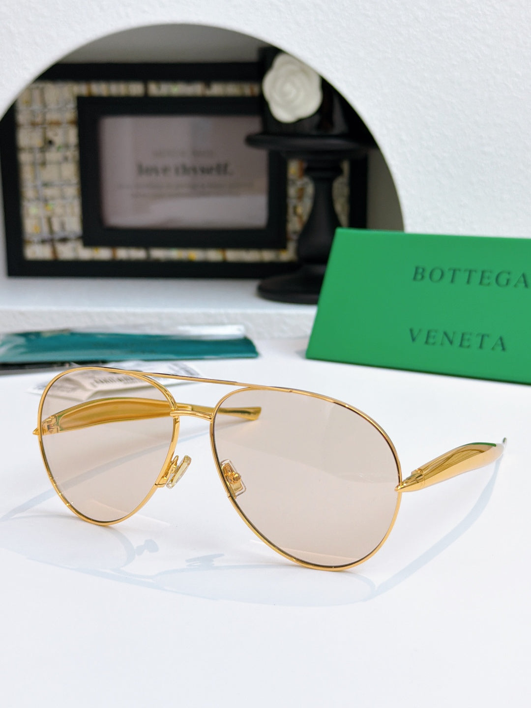 Bottega Veneta sunglasses with gold frame and amber tinted lenses