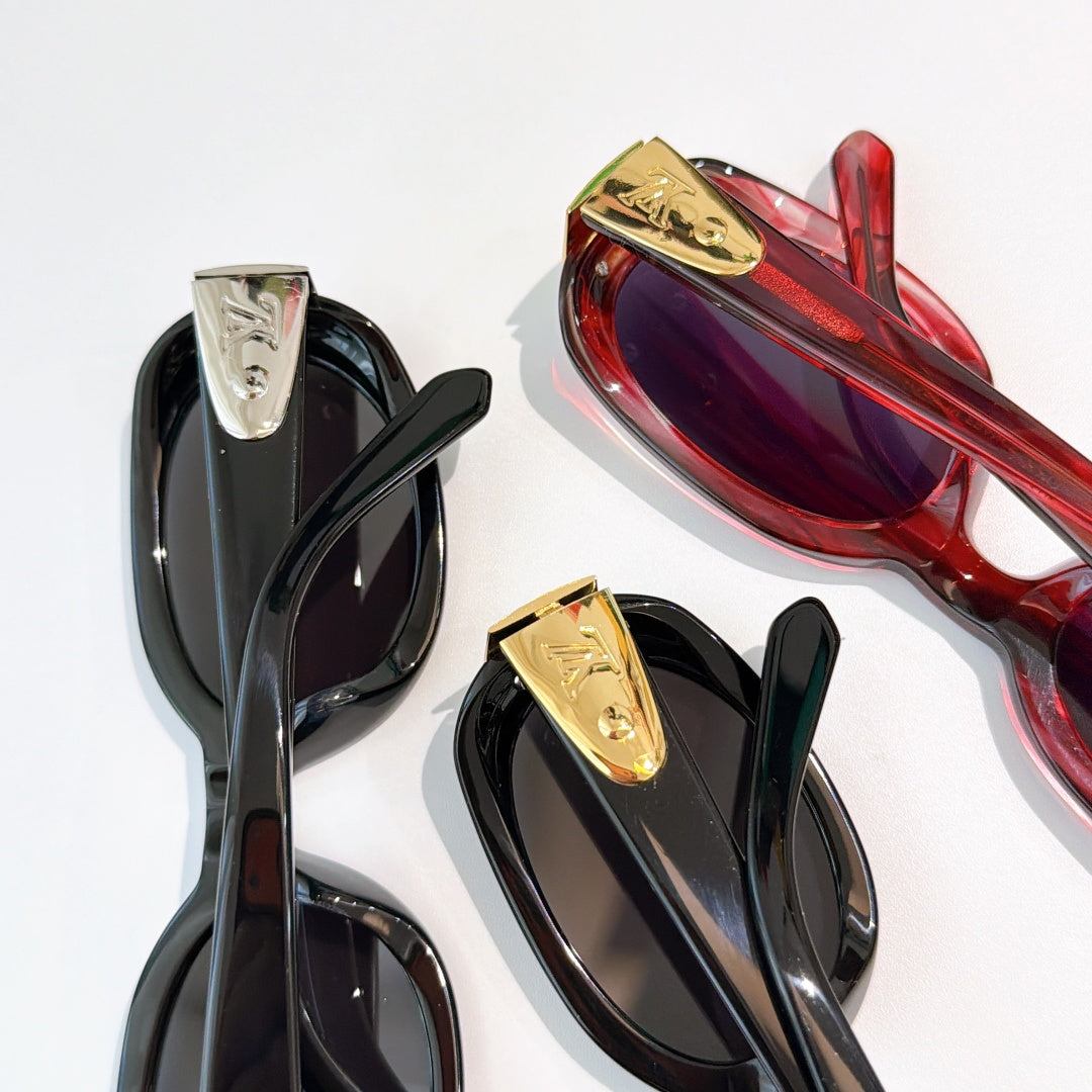 Sunglasses close-up: black frames with gold-tone logo detail and dark lenses