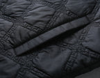 Black quilted jacket close-up, stitched panels and diagonal channel pattern