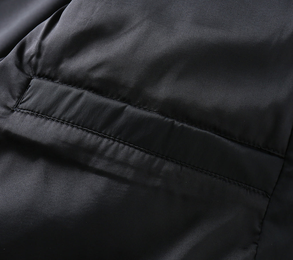 Black jacket lining close-up with horizontal seam and smooth fabric panel