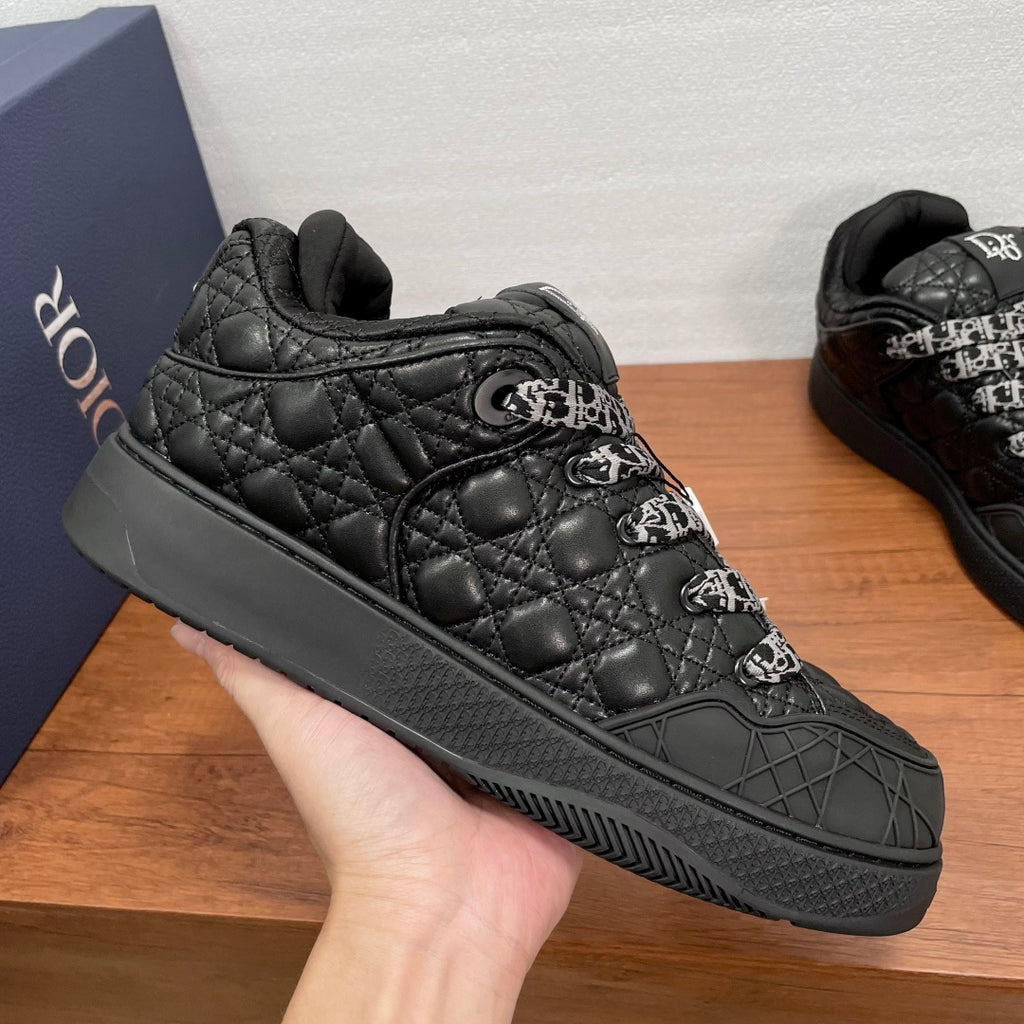 Black quilted low-top sneakers with embossed logo stitching and side panel details