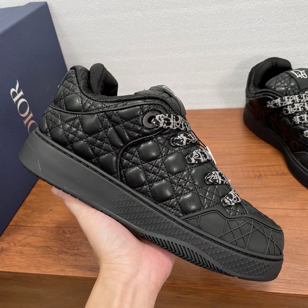 Black quilted low-top sneakers with embossed logo stitching and side panel details