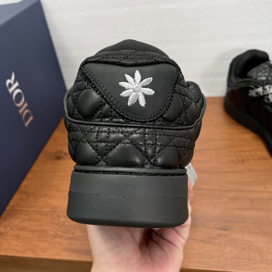 Black quilted sneaker heel with white flower embroidery and thick black rubber sole