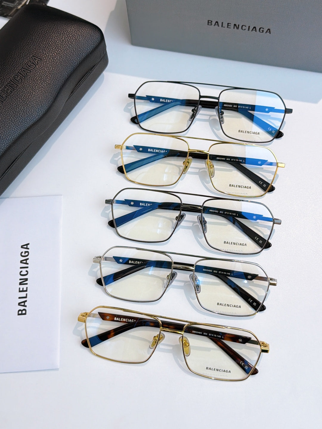 Assorted eyeglasses with blue-tinted lenses and mixed gold and black frames.