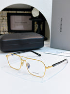 Gold metal eyeglasses with clear lenses and black temple branding.