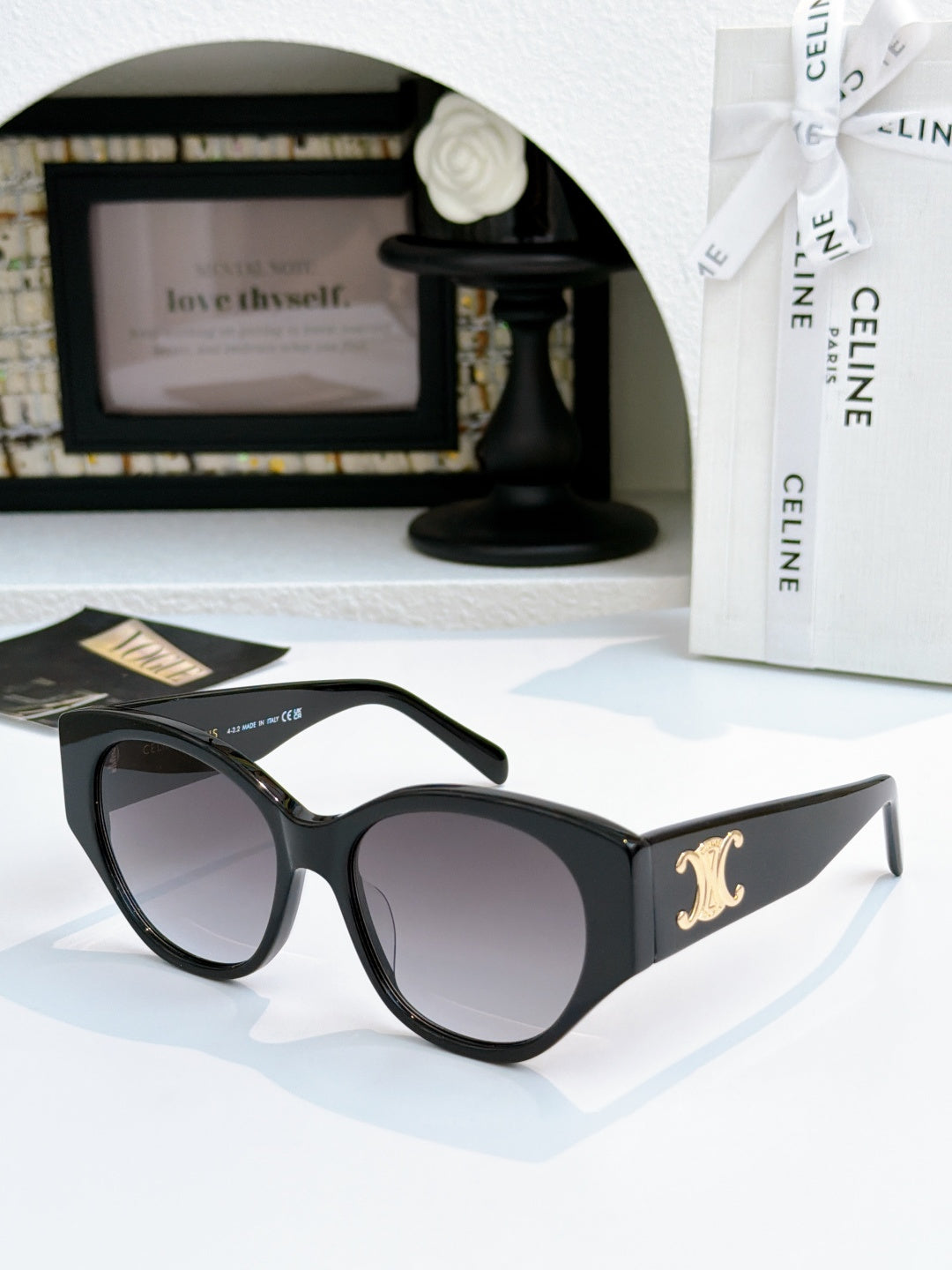 Celine cat-eye sunglasses with black frame and dark lenses, gold logo on side