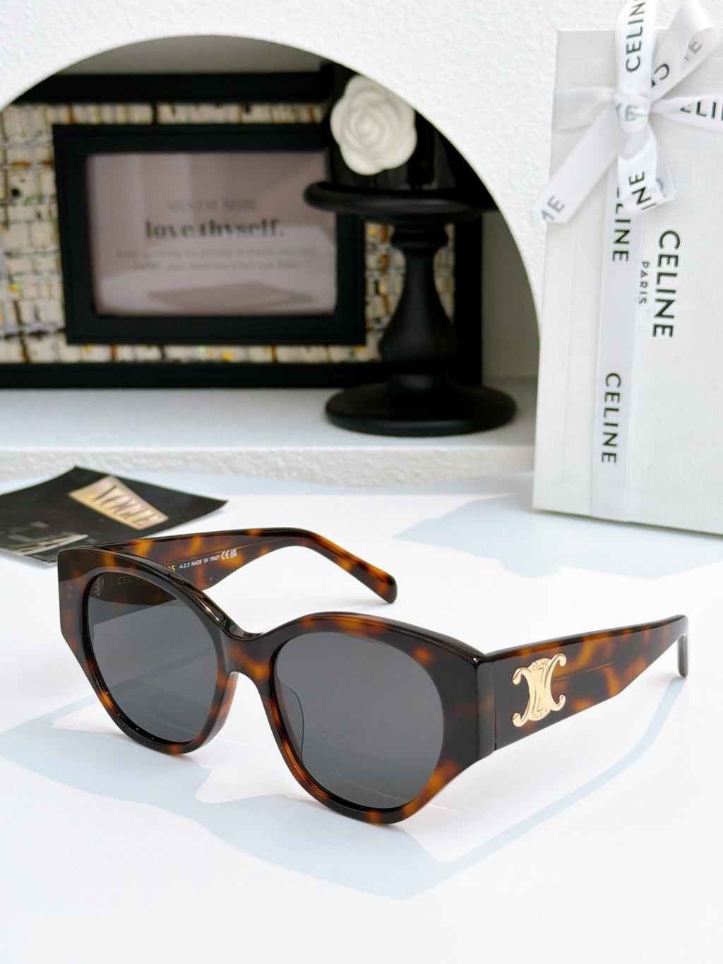 Celine cat-eye sunglasses with tortoiseshell frame and dark lenses, gold logo on temple