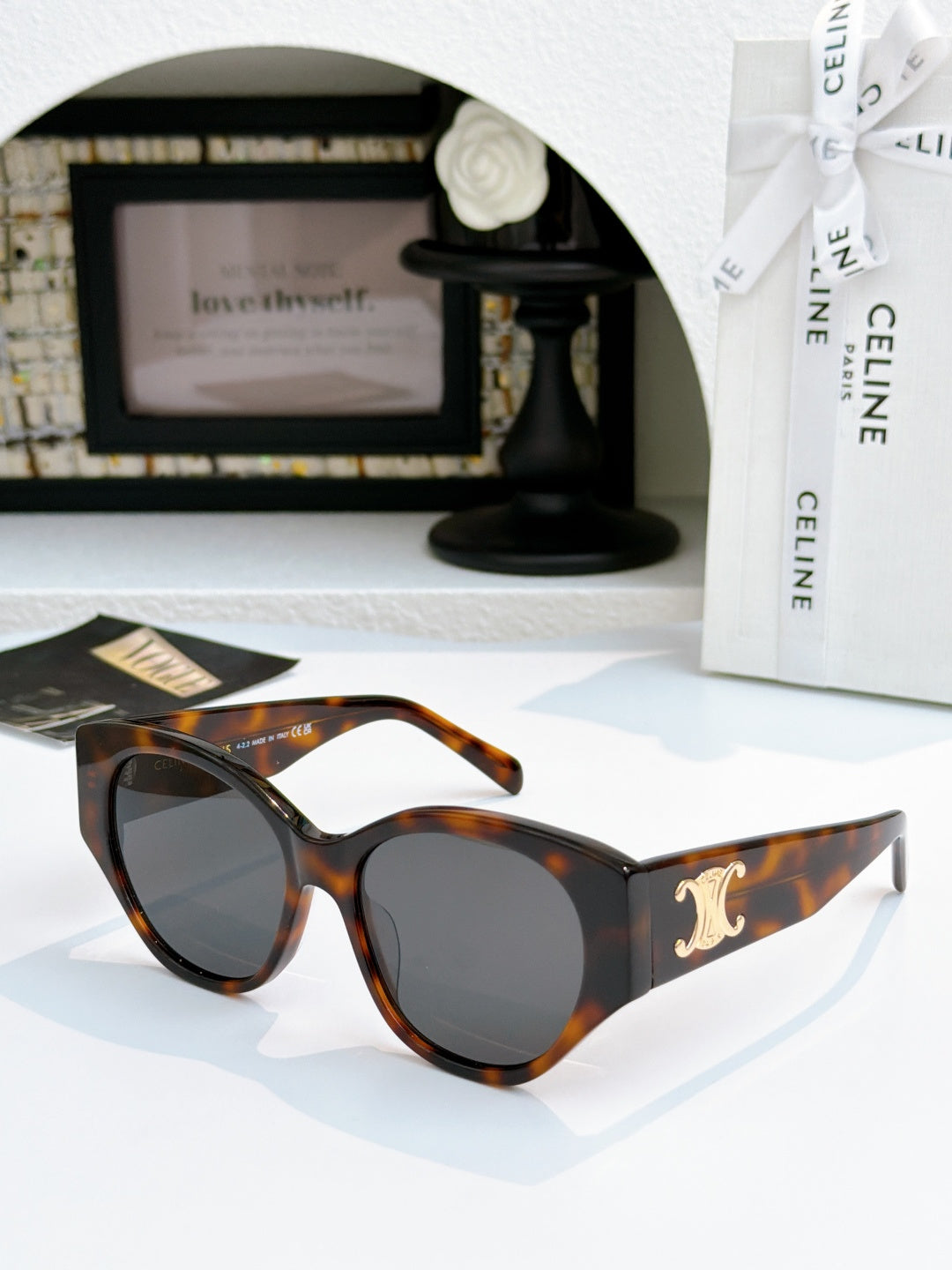 Celine cat-eye sunglasses with tortoiseshell frame and dark lenses, gold logo on temple