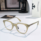Olive-beige round glasses with gold-toned accents and patterned temples