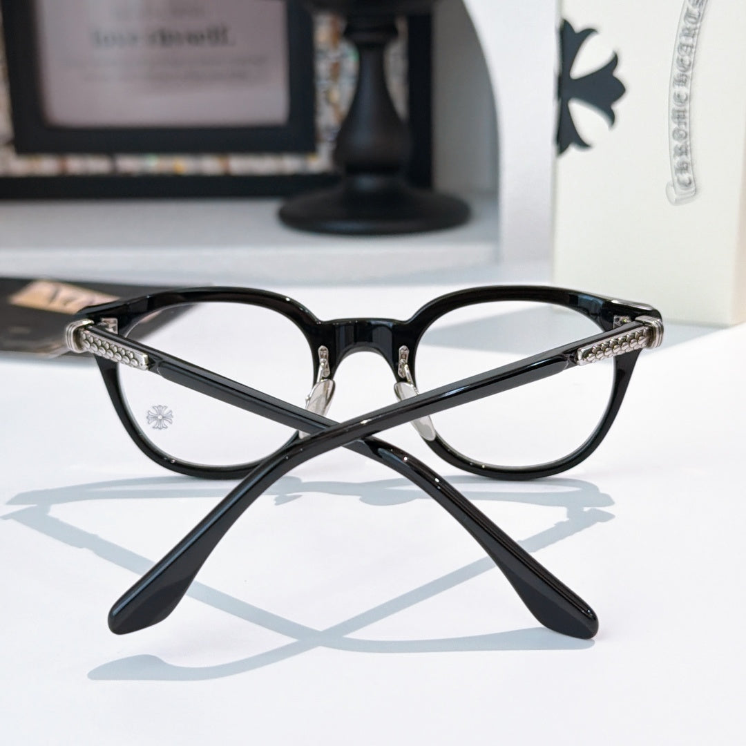 Black round glasses with gold-toned patterned temples