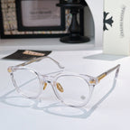Clear round glasses with gold-toned hinge accents and decorative temples