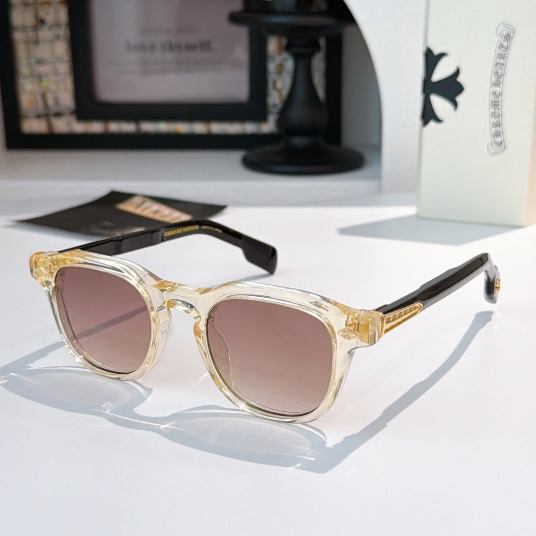 Clear-gold sunglasses with pink-tinted lenses and gold logo accents.