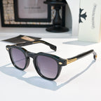 Black sunglasses with purple-tinted lenses and gold logo accents.