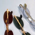 Dior sunglasses close-up with gold-tone frames and dark oval lenses on display