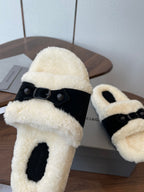 Balenciaga shearling slide sandal with black strap and cream fuzzy band, close-up on box