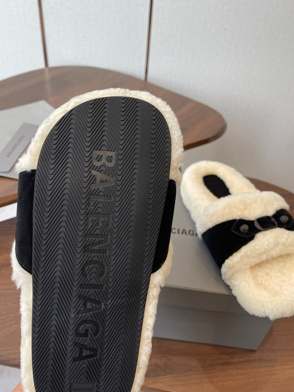 Balenciaga sandal outsole with textured black tread and cream shearling trim, close-up