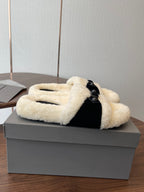 Balenciaga shearling slide sandals with black base and cream fluffy straps, side on box