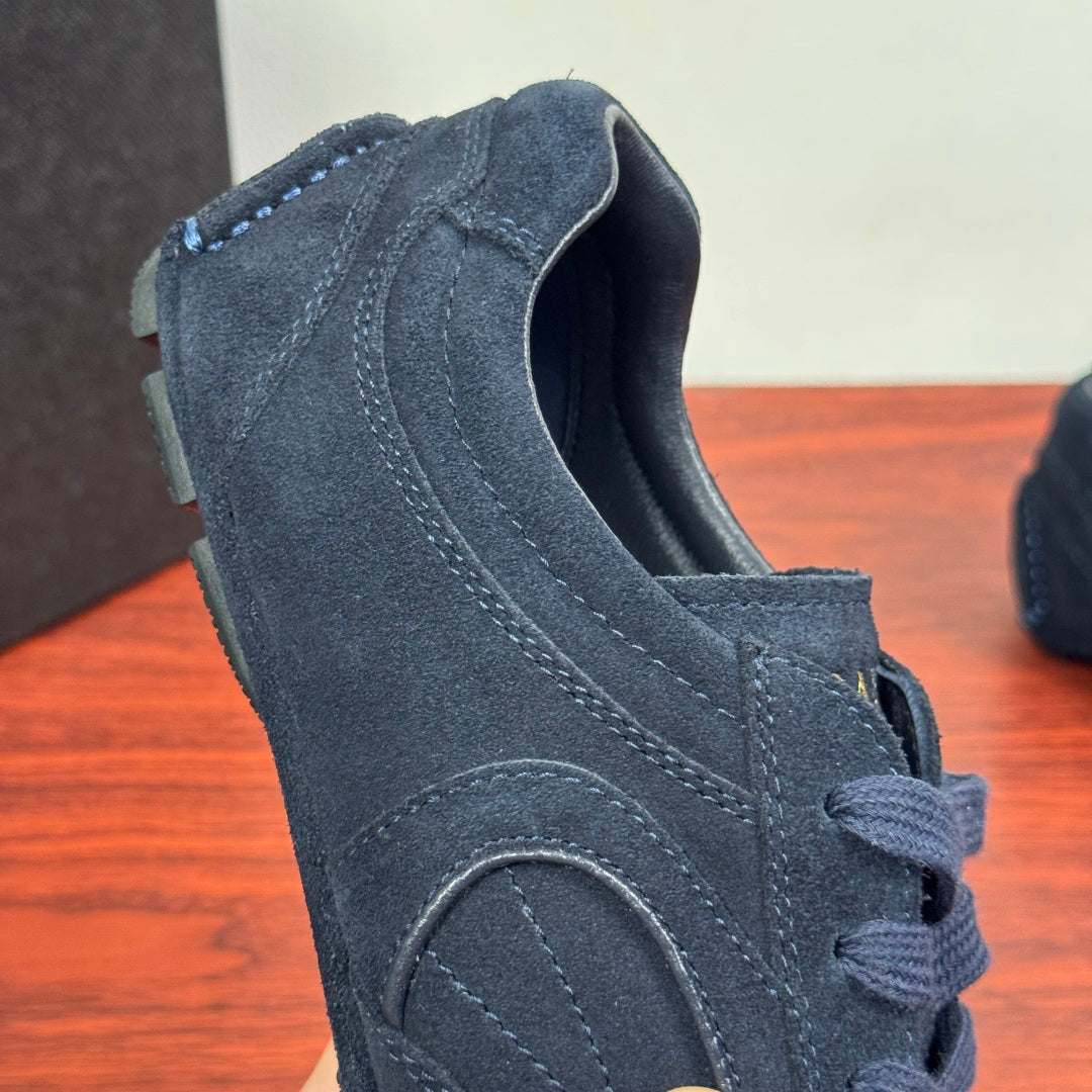 Navy suede Prada sneaker heel view with stitched seams and lace-up opening
