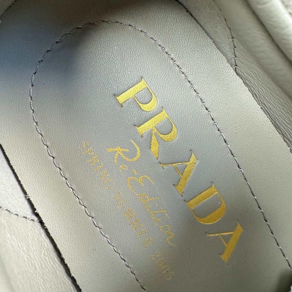 Prada logo on light gray suede insole lining, yellow text