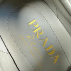 Prada logo on light gray suede insole lining, yellow text