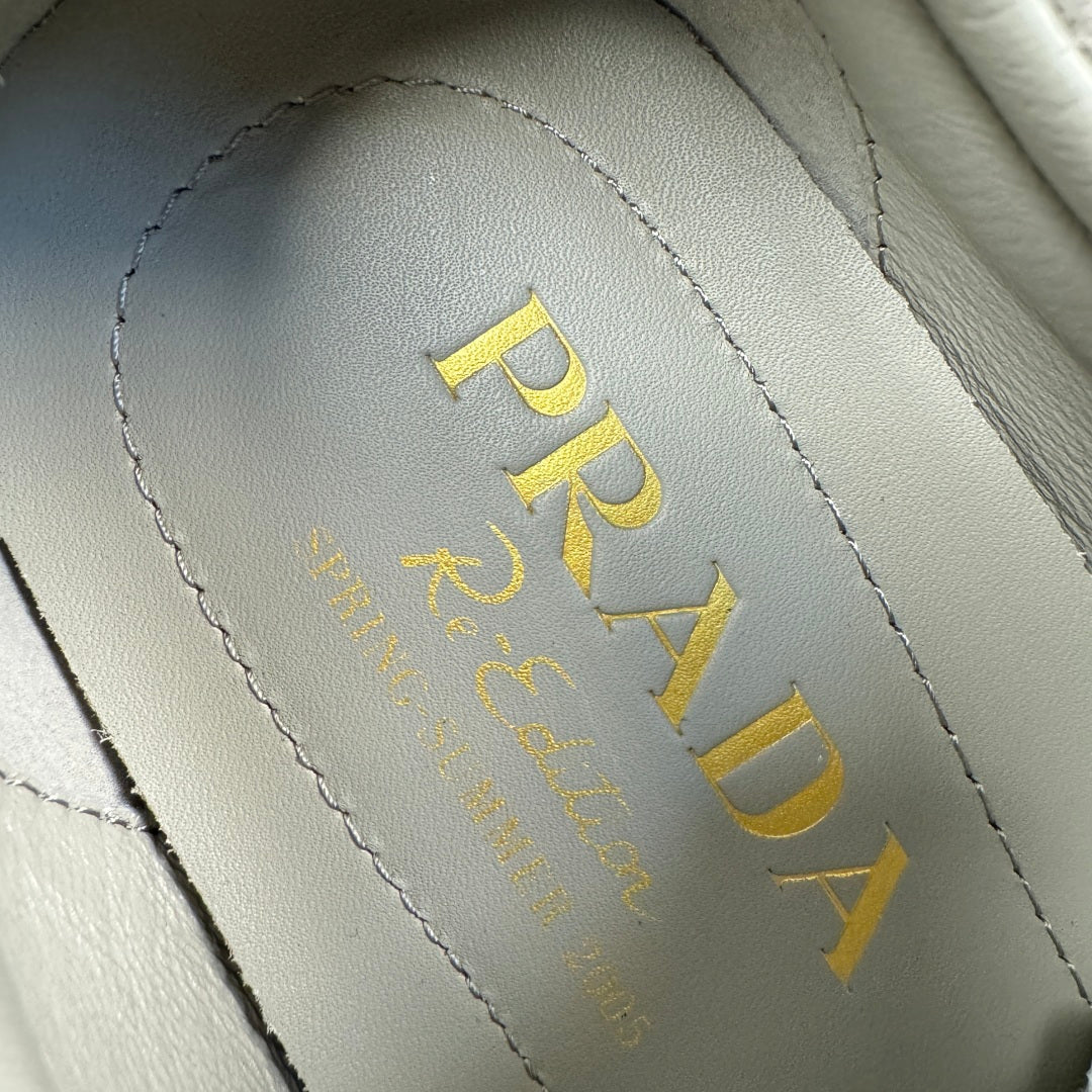 Prada logo on light gray suede insole lining, yellow text