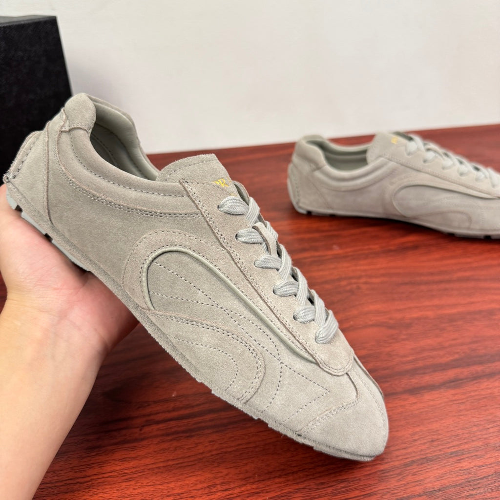 Light gray suede sneakers with lace-up front, viewed from side