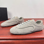 Light gray suede sneakers with lace-up design and rounded toe