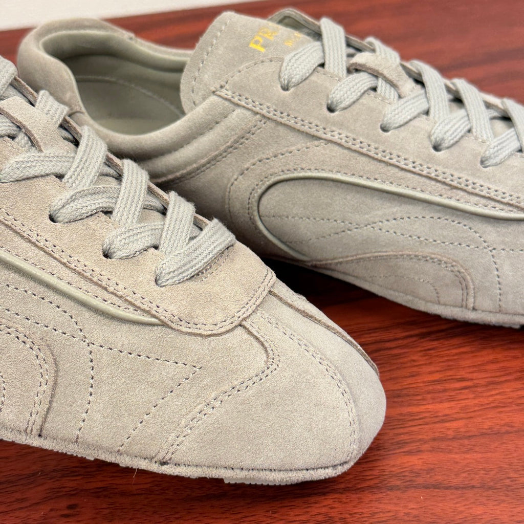 Light gray suede sneakers, close-up of lace panel and stitching
