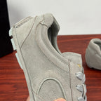 Light gray suede sneakers heel and collar detail with lace-up eyelets