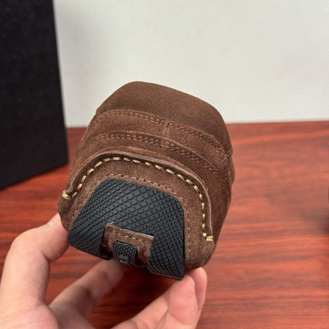 Brown suede sneaker outsole with dark tread and stitched edge