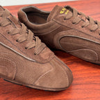 Brown suede sneakers close-up, lace-up front and side logo panel