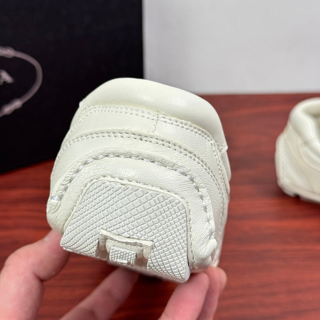 White sneaker outsole toe section with textured grip and embossed detail